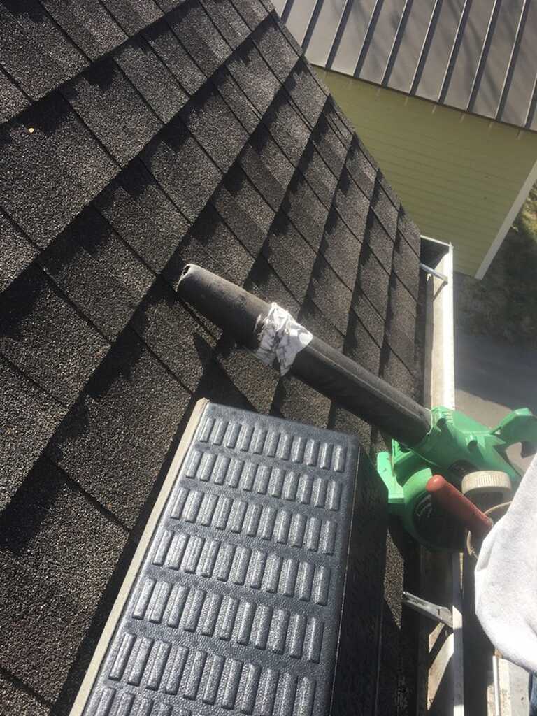 Roofline gutter cleaning equipment on a shingle roof